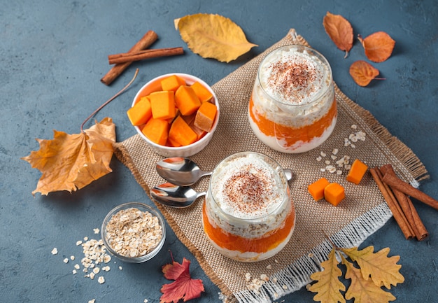 Postre con crema de calabaza y cereales sobre un fondo azul oscuro Postre de otoño