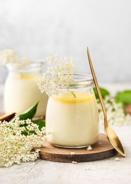 Postre de crema de cotta de panda de flores de saúco con cuajada de limón en frascos de vidrio vintage