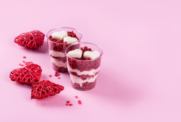 Postre delicioso y hermoso, terciopelo rojo en tazas. Corazones de chocolate blanco. Día de San Valentín.