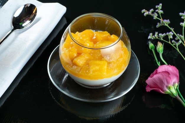 Postre delicioso poco en vasos. Postre con crema batida, fruta, mango. Dulces después del almuerzo. Foto de comida para receta o menú