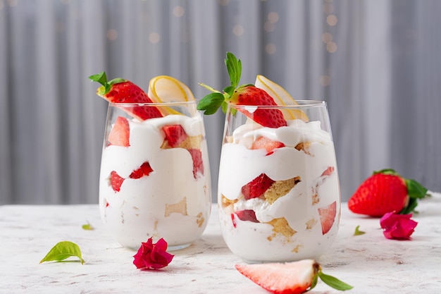 Postre dulce en vaso con bayas de galleta y crema batida