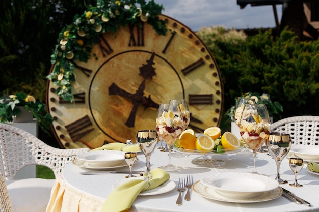 Postre dulce en vasos grandes en la mesa servida para banquetes de bodas