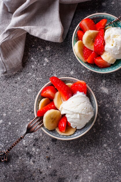 Postre de fresa, plátano y helado.