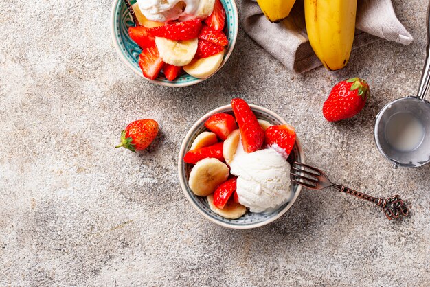 Postre de fresa, plátano y helado.