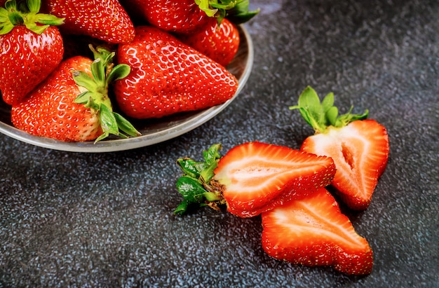 Postre fresas frescas en placa sobre superficie gris