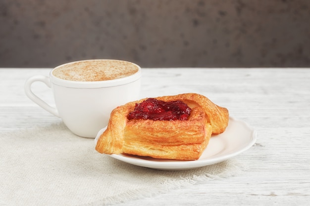 Postre de frutas y café en una mesa de madera blanca