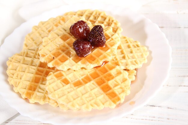 El postre de galletas de gofres y mermelada de fresa se encuentra en un plato