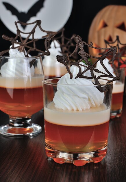 Postre de gelatina con crema y telarañas de chocolate