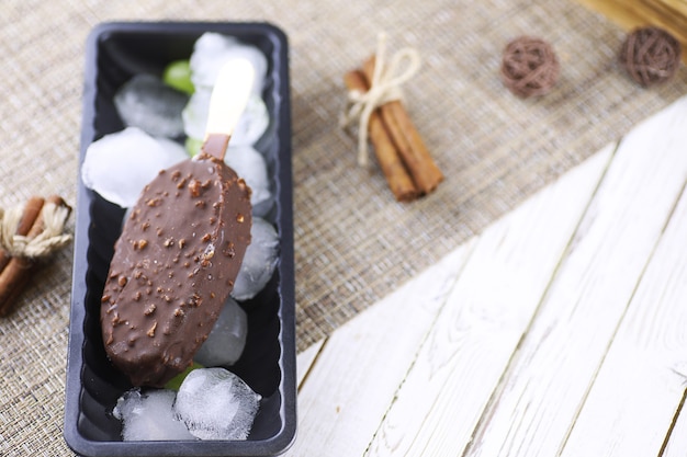 Postre helado de chocolate con nueces en un palo de madera