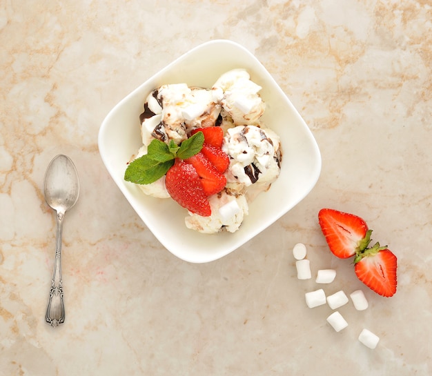 Postre con helado y fresas con chocolate