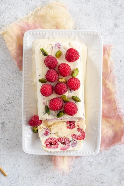 Foto postre de helado italiano semifreddo con frambuesa y pistachos