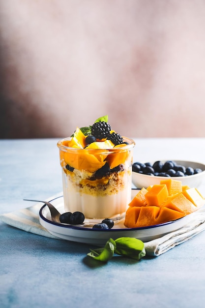 Postre insignificante con bayas y crema en una mesa de madera Espacio para copiar