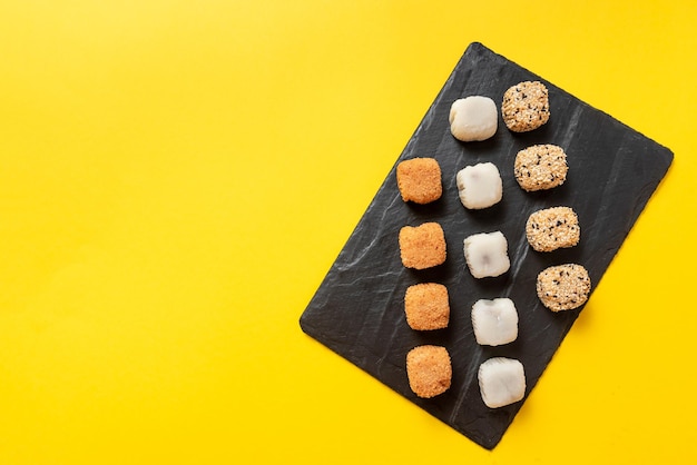 Postre japonés empaquetado sobre un fondo amarillo helado japonés mochi en masa de arroz traditio