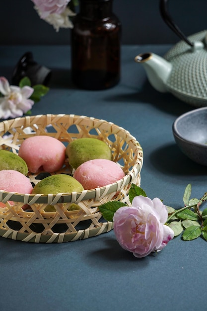 Postre japonés mochi con polvo de té verde matcha y ceremonia japonesa del té de cereza