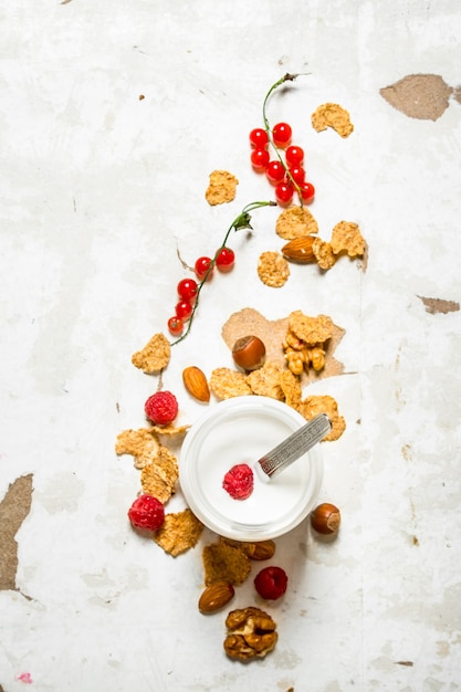 Foto postre de leche con cereales, frutos secos y frutos del bosque.