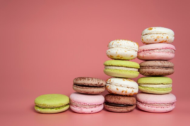 Postre de macarrones sobre fondo rosa