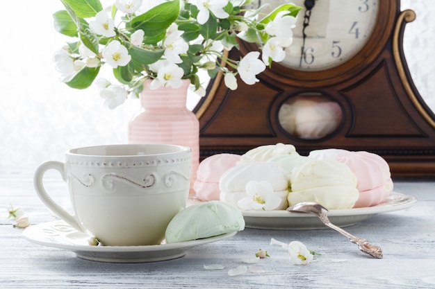 Postre de malvavisco o zefir en un plato blanco con ramas de manzana floreciente