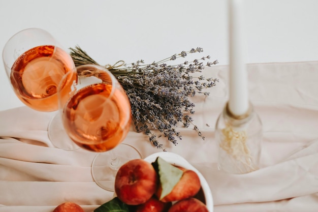 Postre de melocotones y copa de vino sobre fondo blanco mínimo