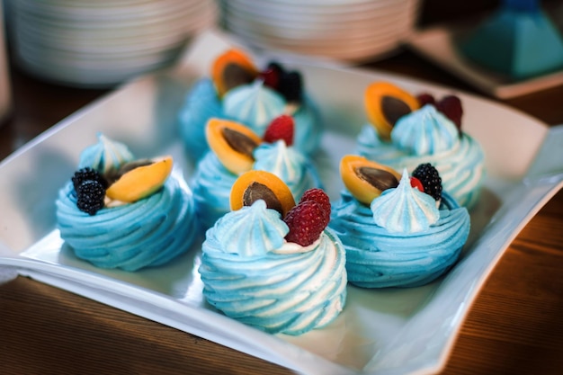 Postre de merengue Pastel Pavlova con bayas frescas en un plato blanco Hermosos pasteles azules Clouseup