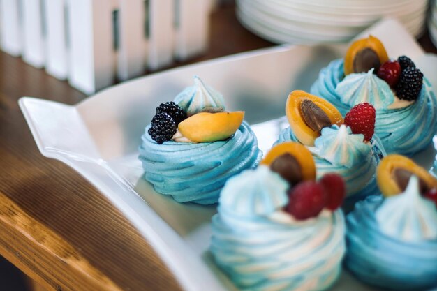 Postre de merengue Pastel Pavlova con bayas frescas en un plato blanco Hermosos pasteles azules