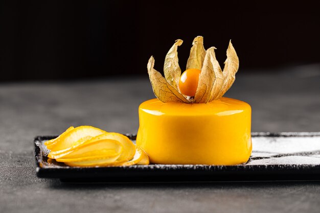 Postre mousse amarillo decorado con physalis