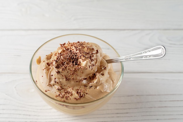 Postre de mousse de café con crema sobre mesa blanca