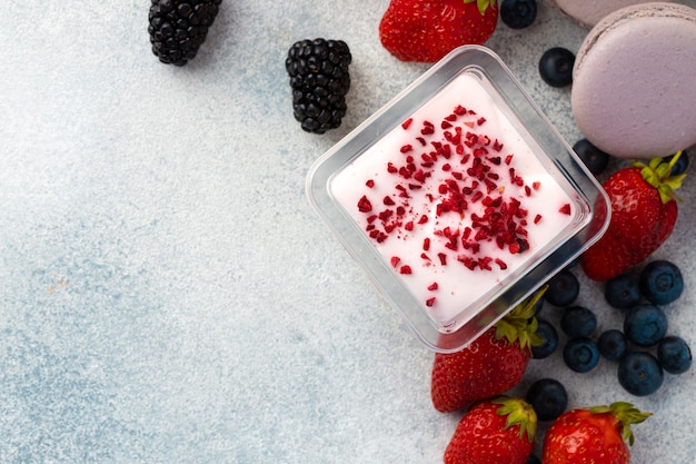 Foto postre de mousse con cobertura de bayas en superficie gris