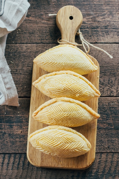 Postre nacional de azerbaiyán. Postre dulce oriental de los pasteles - Shekerbura en fondo de la tabla de madera