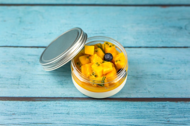 Postre Panna cotta casera con mango sobre un fondo de madera azul