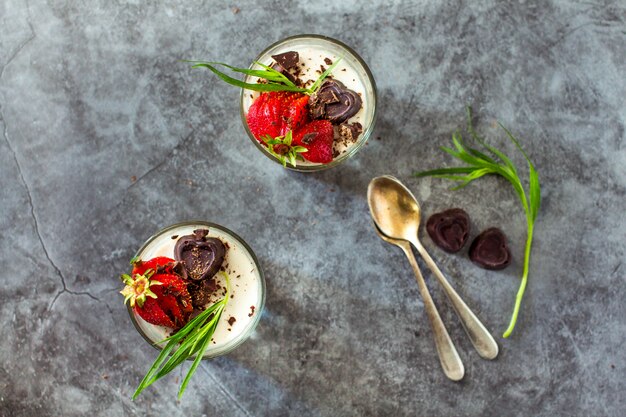 Postre de panna cotta con fresas y estragón en gris vintage