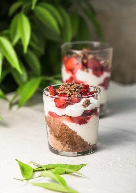 Postre de parfait en capas de desayuno con bizcocho de yogur y espacio de copia de fondo blanco de fresa fresca