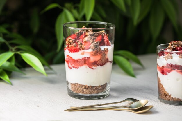 Postre de parfait en capas de desayuno con bizcocho de yogur y espacio de copia de fondo blanco de fresa fresca