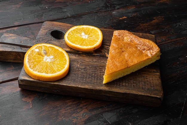 Postre de pastel de harina de maíz naranja, sobre fondo antiguo de mesa de madera oscura.