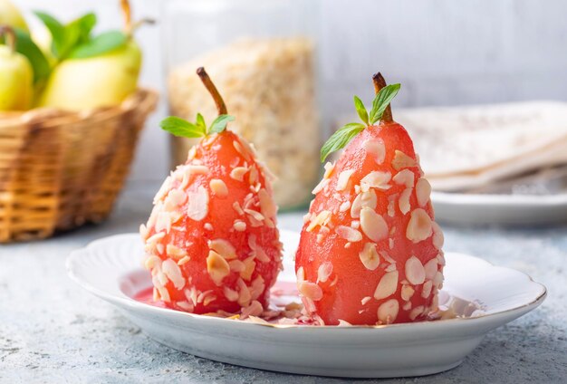 Un postre de pera escalfada espolvoreada con trozos de almendras Una muestra de postres turcos Postre de pera Peras escalfadas en vino tinto