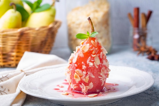 Un postre de pera escalfada espolvoreada con trozos de almendras Una muestra de postres turcos Postre de pera Peras escalfadas en vino tinto