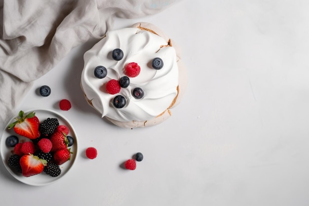 Un postre con un plato de bayas frescas sobre la mesa.