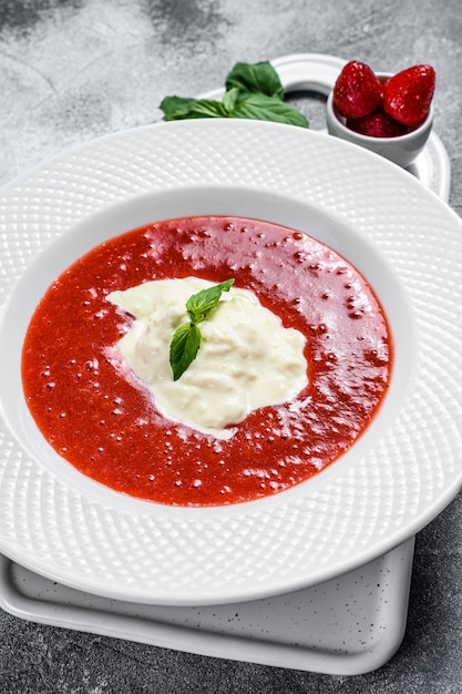 Postre de puré de fresa y mozzarella de stracciatella. Mesa gris