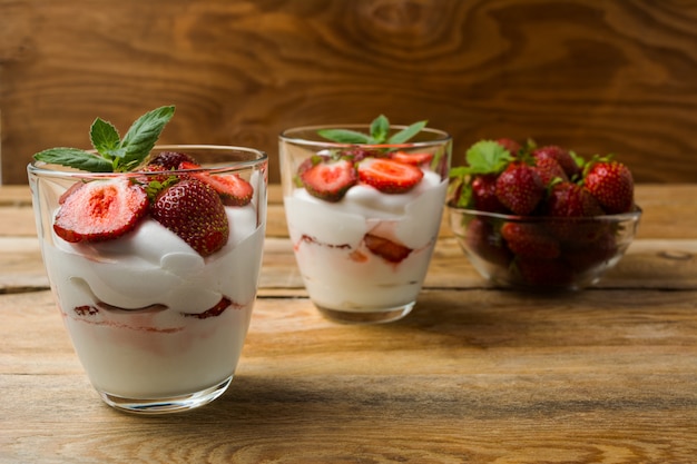 Postre de queso crema de fresas sobre fondo de madera