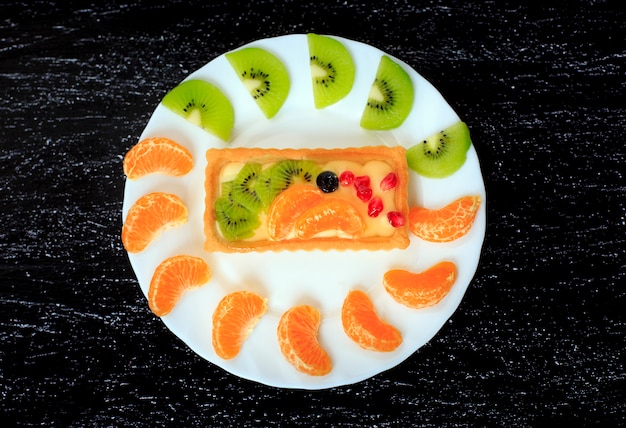 Foto postre saludable con dulces pasteles y frutas en una mesa negra