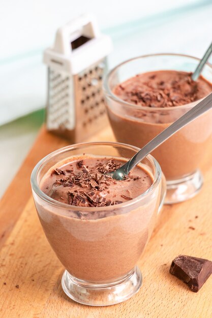 Postre saludable con pudín de chocolate tazas para servir tablas de cortar de madera Enfoque selectivo