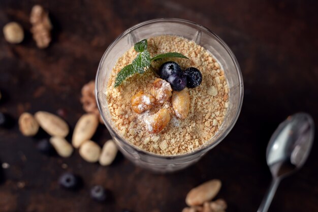 Postre saludable de yogurt, nueces y granola en vidrio