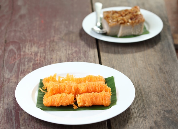 Postre tailandés, cuadrados de crema de coco e hilos dorados.