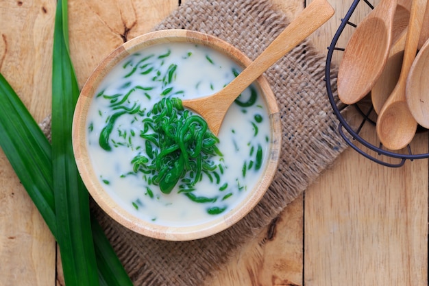 Foto postre tailandés, fideos de arroz hechos de arroz comido con leche de coco en la mesa de madera