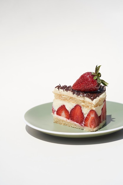 Postre de tarta de queso con fresas sobre fondo blanco.