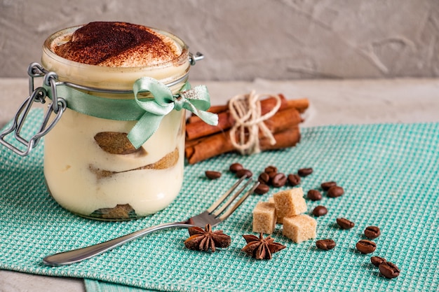 Postre de tiramisú en un frasco con un lazo azul