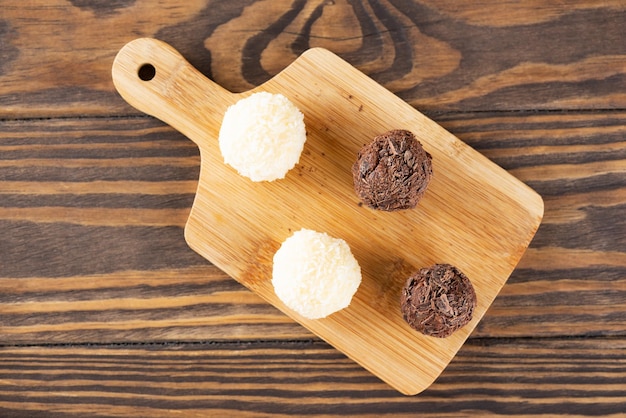 Postre tradicional brasileño trufas de brigadeiro con chocolate y coco en una tabla