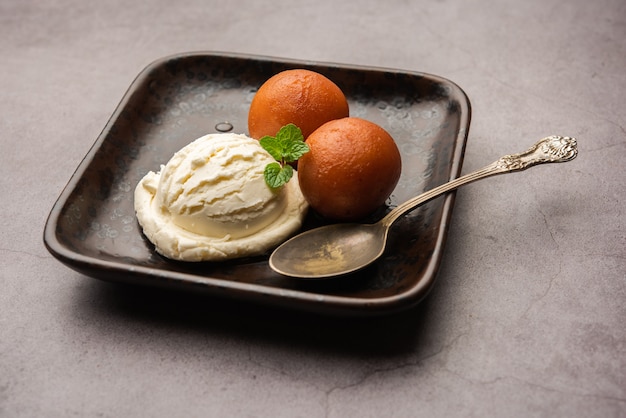 Postre tradicional indio Gulab Jamun servido con helado de vainilla