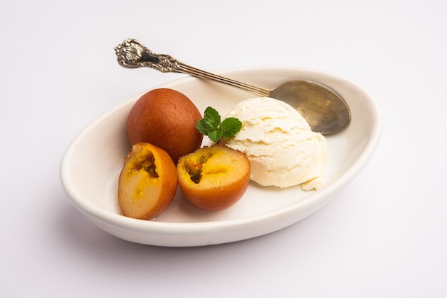 Postre tradicional indio Gulab Jamun servido con helado de vainilla