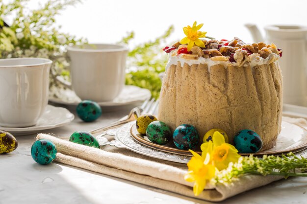 Postre tradicional ruso de requesón de pascua, paskha ortodoxa en la mesa con pasteles de kulich, flores, huevos de colores.