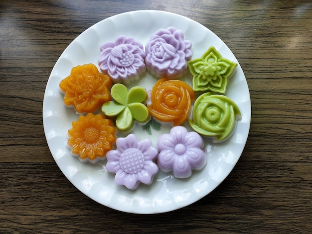 Postre tradicional tailandés jalea de leche de coco flores sobre fondo de madera